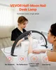 Two women are at a table, one is having her nails done by the other, with a large half-moon desk lamp illuminating the area. Voir les images du produit
