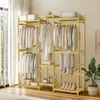 A wooden garment rack with clothes hanging on it, placed in a room with a window and curtains. Produktbild-Vorschau