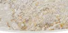 A close-up view of a round rug with a textured pattern in beige and gold tones. Anteprima dell’immagine prodotto