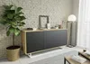 A modern living room with a sideboard, a plant, and a floor lamp.