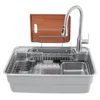 A stainless steel kitchen sink with a faucet, dish rack, and cutting board. Podgląd zdjęcia produktu