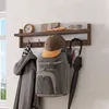 A wall-mounted organizer with a shelf and hooks holding various items. Produktbild-Vorschau