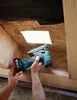 Hands using a power tool to cut into a wooden structure. Produktbild-Vorschau