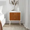 A white and wood-grain nightstand next to a bed. Produktbild-Vorschau