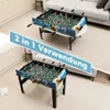Two foosball tables are shown in a living room setting. One is on a coffee table, and the other is on the floor. A blue banner with text is overlaid on the image. Náhľad obrázku produktu