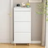 A white shoe cabinet with three drawers stands against a wall next to a white door. Produktbild-Vorschau