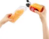 Hands pouring orange gel pellets from a bottle into a clear container. Voir les images du produit