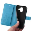 A hand is holding a blue flip cover phone case, showing the inside with card slots and floral embossed design. Produktbild-Vorschau