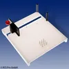 A white cutting board with various features, including a red-handled lever, a slot, and metal pins, is shown against a blue background. Produktbild-Vorschau