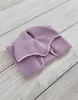 A folded purple fleece blanket with pink trim is laid on a light gray wooden surface. Náhľad obrázku produktu