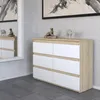 A modern dresser with white drawers and a wood-tone top and sides, placed in a room with textured wallpaper and a mirror reflecting another dresser. Produktbild-Vorschau