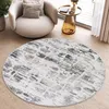 A round rug with a distressed brick pattern is placed on a wooden floor in a living room setting, next to a modern armchair and a side table.