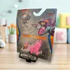 A Paw Patrol Skye toy vehicle in its packaging, displayed on a wooden surface with blurred background elements like a mug, plants, and building blocks. Produktbild-Vorschau