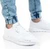 A person wearing white Puma sneakers and blue jeans. Anteprima dell’immagine prodotto