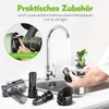 A person is cleaning parts of a green juicer under a kitchen faucet. Several disassembled juicer parts are laid out on the counter. Produktbild-Vorschau