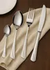 A set of cutlery laid out on a beige cloth on a wooden table. Produktbild-Vorschau