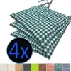 A stack of four green and white checkered seat cushions. Produktbild-Vorschau