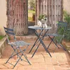 A bistro set with a table and two chairs on a brick patio in front of a rustic wooden door. Produktbild-Vorschau