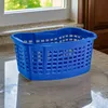 A blue laundry basket sits on a speckled countertop in front of a window. Voir les images du produit