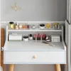 A vanity table top with various makeup and skincare products organized on shelves and the main surface. Produktbild-Vorschau