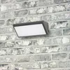 A modern LED outdoor wall light mounted on a brick wall. Produktbild-Vorschau