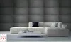 A modern living room with a sectional sofa and a coffee table against a textured gray wall. Anteprima dell’immagine prodotto