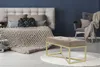 A bedroom scene with a bed, armchair, and a bench. Produktbild-Vorschau