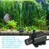 A small black water pump is shown in an aquarium with lush green plants and a blue fish. Náhľad obrázku produktu