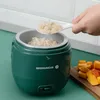A hand is adding rice to a green mini rice cooker on a green countertop. Produktbild-Vorschau