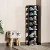 A black wooden shoe rack with multiple shelves filled with slippers, placed next to a furry stool and a plant. Podgląd zdjęcia produktu
