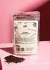 A pouch of bourbon vanilla powder is placed on a pink surface, with a pile of the powder spilled in front of it. Produktbild-Vorschau