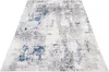 A modern abstract rug with cream, gray, and blue tones, shown from a diagonal perspective on a white background. Náhled obrázku produktu
