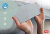Hands holding a piece of light gray fabric, likely a bedsheet, with marketing icons on the left. Produktbild-Vorschau