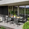 An outdoor dining set on a wooden deck, with a modern house and landscape in the background. Náhled obrázku produktu