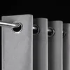 A close-up view of several grey grommet curtains hanging on a metal rod against a black background. Voir les images du produit