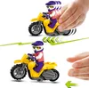 Two images of a LEGO stunt motorcycle with a minifigure rider, demonstrating movement. The top image shows a hand pushing the motorcycle, with motion blur indicating speed. The bottom image shows the motorcycle stationary, with a hand reaching towards it. Náhled obrázku produktu