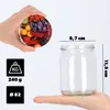 A hand holding a jar lid with a fruit pattern and a glass jar with dimensions indicated. Anteprima dell’immagine prodotto