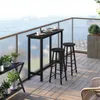 A black bar table and two stools are set up on a balcony overlooking the ocean. Náhľad obrázku produktu