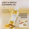 A bottle of cleansing oil is shown with text overlays and a close-up of a hand using a pump dispenser. Voir les images du produit
