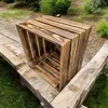 Two wooden crates are placed on a wooden surface outdoors, with grass and bushes in the background. Anteprima dell’immagine prodotto
