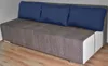 A sofa with three blue cushions on a wooden floor. Anteprima dell’immagine prodotto