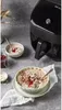 An Instant Pot Vortex Plus Airfryer is shown next to bowls of oatmeal, with a jar of jam and some scattered oats in the foreground. Produktbild-Vorschau