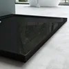 A close-up, low-angle shot of a black shower tray in a modern bathroom setting. Produktbild-Vorschau