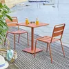 A square table and two chairs set up on a wooden deck by the water, with drinks on the table. Produktbild-Vorschau