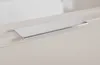 A close-up shot of a silver handle on a light-colored cabinet or drawer. Produktbild-Vorschau