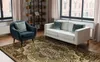 A living room scene with a sofa, armchair, and a rug. Voir les images du produit