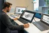 A man is working at a desk with multiple computer monitors, designing something on a computer. Voir les images du produit