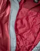 Close-up view of the inside lining of a jacket, showing quilted stitching and a zipper. Produktbild-Vorschau