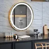 A round mirror with a gold frame and LED light is mounted on a marble-tiled wall above a dark vanity. Several small glass bottles and a clock are on the vanity. Produktbild-Vorschau