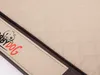 A close-up view of a quilted dog mat with a branded label. Produktbild-Vorschau